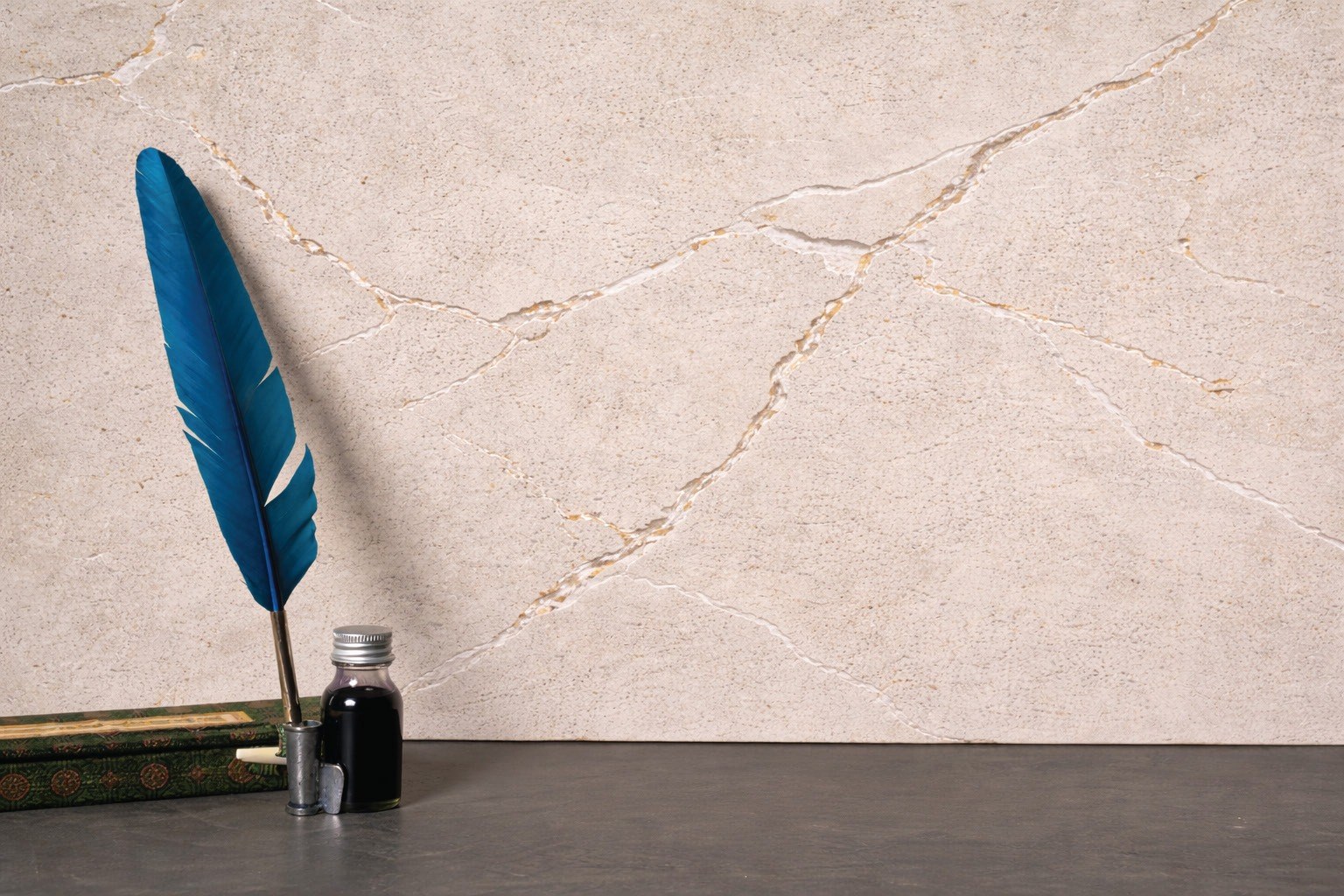Pale mineral plaster wall with a blue feather